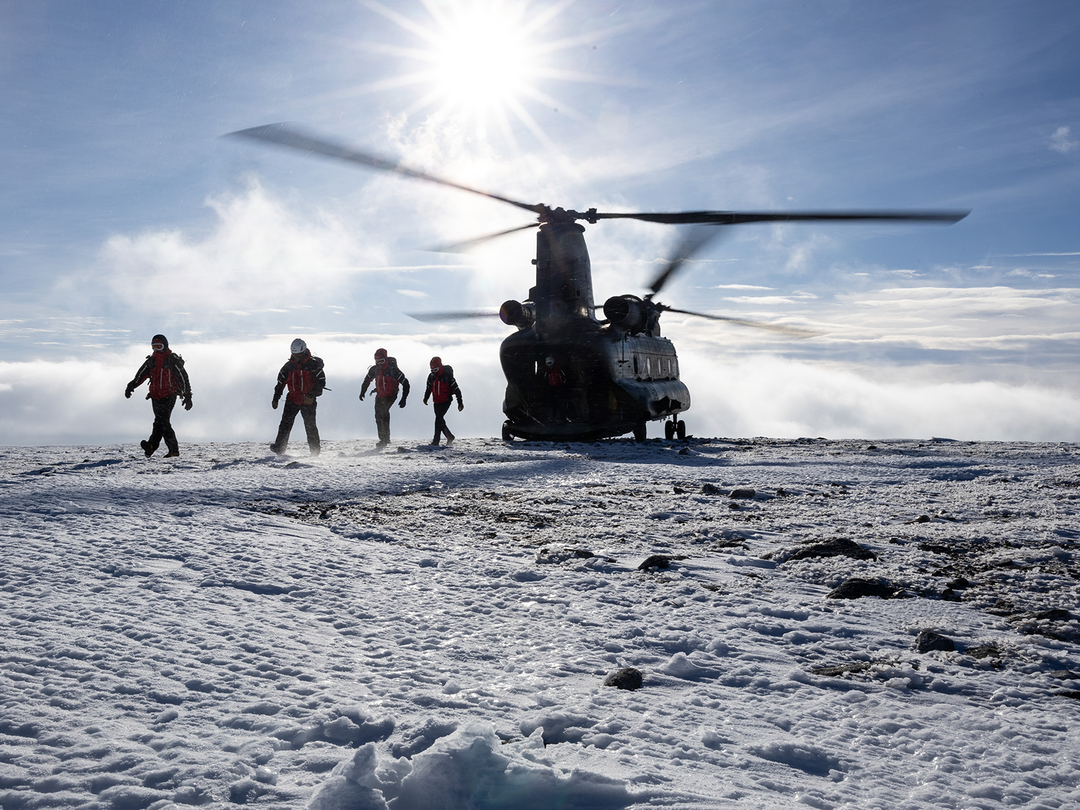 Army personnel leaving a chinook Helicopter