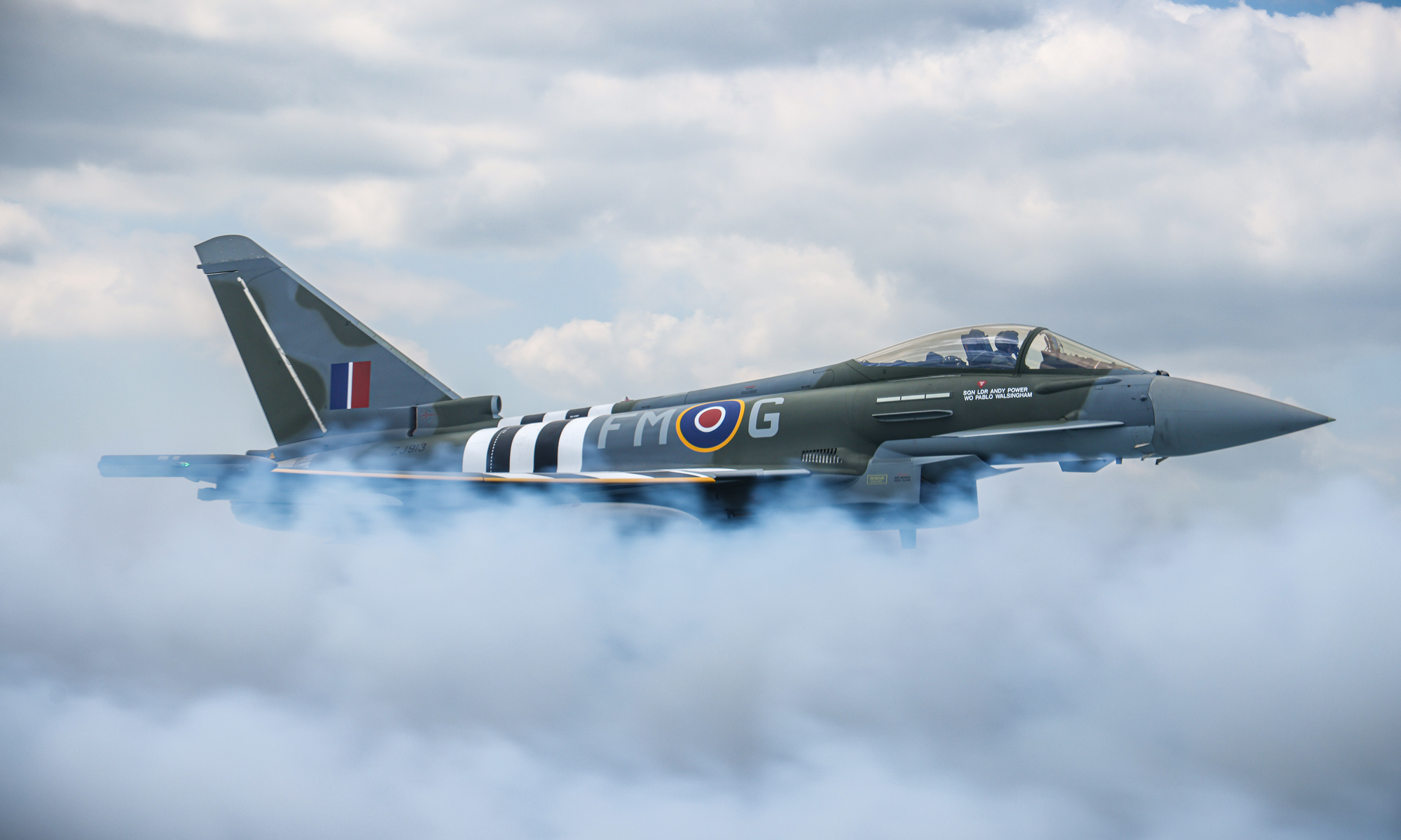 Typhoon Military jet flying through clouds with visible branding