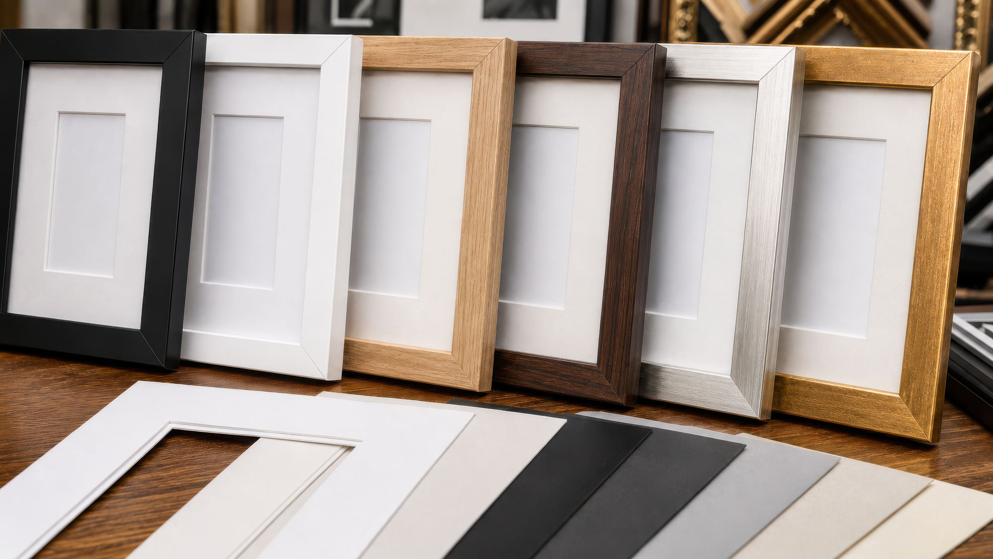 Row of variously colored picture frames on a wooden surface.